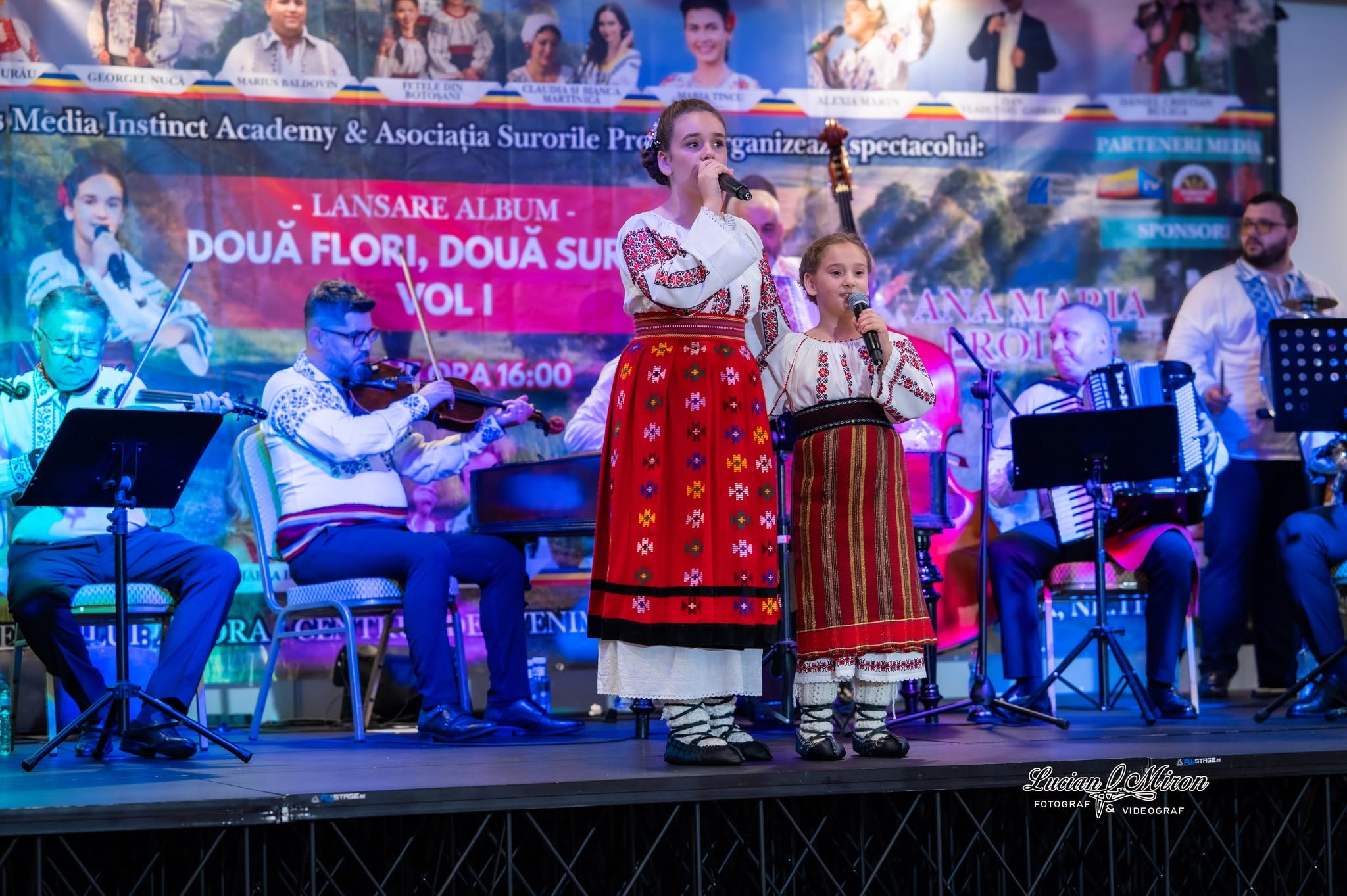 Surorile Prodan cântând pe scenă, în costum popular, la lansarea albumului „Două flori, două surori”